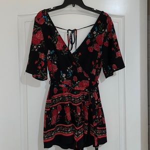 Black women’s romper with red floral design size Medium from Francesca’s